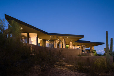 Inspiration for a large contemporary brown one-story stucco exterior home remodel in Phoenix with a metal roof