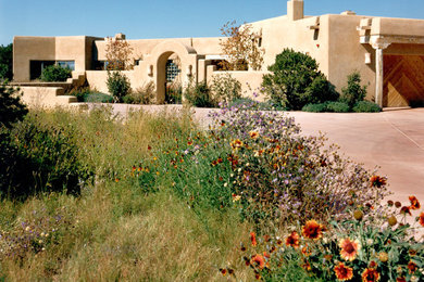 Example of a large southwest beige one-story stucco exterior home design in Other