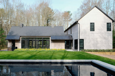 Imagen de fachada de casa gris de estilo de casa de campo de dos plantas con revestimiento de madera, tejado a dos aguas y tejado de varios materiales