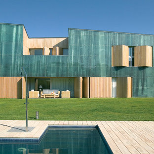Imagen de fachada verde, contemporánea, extra grande, de dos plantas, con revestimientos combinados y tejado de un solo tendido