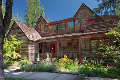 Imagen de fachada marrón de estilo de casa de campo grande de dos plantas con revestimiento de madera y tejado a dos aguas