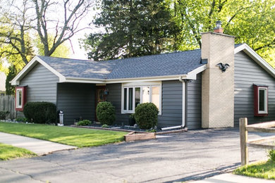 Example of a mid-sized classic black one-story wood house exterior design in Chicago with a hip roof and a shingle roof