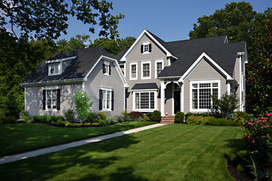 Diseño de fachada de casa beige clásica grande de dos plantas con revestimiento de vinilo, tejado a dos aguas y tejado de teja de madera