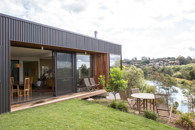 Mittelgroßes, Einstöckiges Modernes Einfamilienhaus mit Metallfassade, schwarzer Fassadenfarbe, Flachdach und Blechdach in Hobart