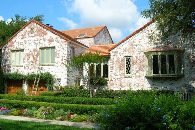 Ejemplo de fachada de casa multicolor rústica grande de dos plantas con revestimiento de ladrillo, tejado a dos aguas y tejado de teja de barro