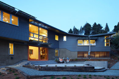 Inspiration pour une façade de maison design de taille moyenne et à un étage avec un revêtement mixte et un toit plat.