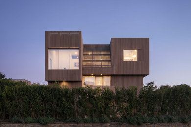 Diseño de fachada de casa gris minimalista grande de tres plantas con revestimiento de madera, tejado plano y tejado de varios materiales