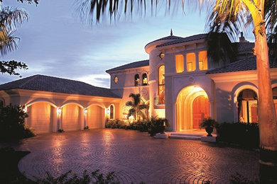 Пример оригинального дизайна: большой, двухэтажный, бежевый дом в классическом стиле с облицовкой из цементной штукатурки и вальмовой крышей
