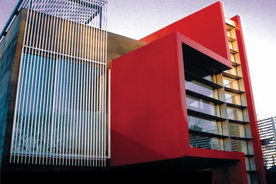 Foto de fachada roja actual grande de dos plantas con revestimientos combinados y tejado plano
