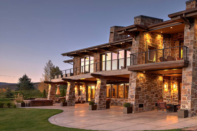 Diseño de fachada de casa marrón rural extra grande de dos plantas con revestimiento de piedra y tejado a dos aguas