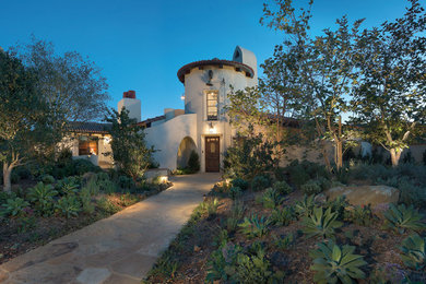 Example of a large tuscan white two-story adobe house exterior design in Los Angeles with a tile roof