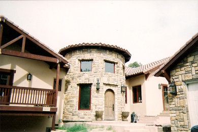 Diseño de fachada beige clásica grande de dos plantas con revestimiento de piedra y tejado a dos aguas