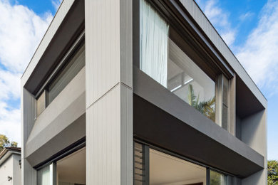 Diseño de fachada de casa verde actual grande de dos plantas con revestimiento de aglomerado de cemento, tejado plano y tejado de metal