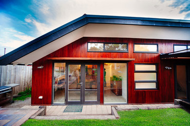 Imagen de fachada de casa marrón actual de tamaño medio de una planta con revestimiento de madera y tejado de metal