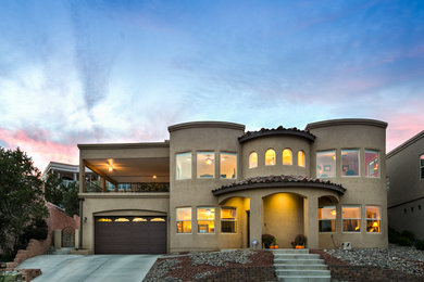 Large southwest brown two-story stucco exterior home photo in Albuquerque