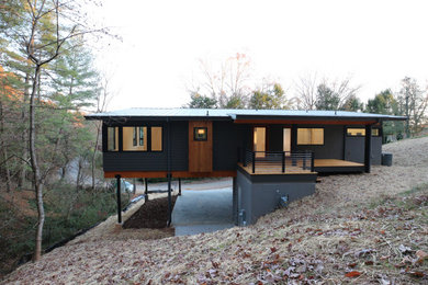 Стильный дизайн: серый частный загородный дом в стиле модернизм с разными уровнями, комбинированной облицовкой, односкатной крышей и металлической крышей - последний тренд