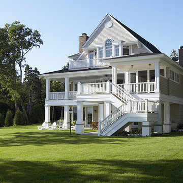Rear view of the homes screened porch and deck from the backyard