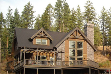 Inspiration for a large rustic two floor house exterior in Boise with stone cladding and a pitched roof.