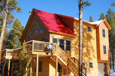 Diseño de fachada de casa marrón rural grande de tres plantas con revestimiento de madera, tejado de metal y tejado a dos aguas