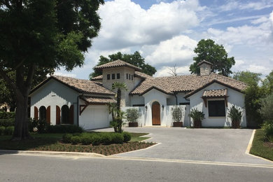 Example of a mid-sized tuscan white two-story stucco gable roof design in Orlando