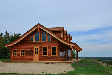Design ideas for a large and brown rustic two floor house exterior in Calgary with wood cladding and a pitched roof.