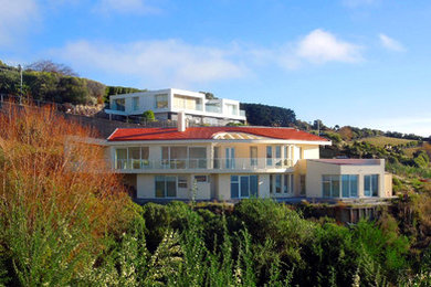 Ejemplo de fachada de casa beige mediterránea grande de dos plantas con tejado de teja de barro y revestimiento de estuco