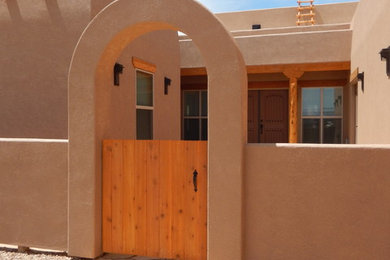 Diseño de fachada de casa de estilo americano de tamaño medio de una planta con revestimiento de estuco y tejado plano