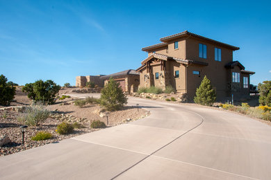 Example of a large mountain style beige two-story stucco exterior home design in Denver with a tile roof