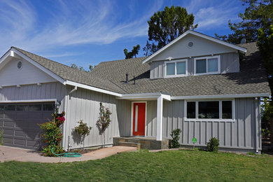 Imagen de fachada de casa gris tradicional de tamaño medio de dos plantas con revestimientos combinados, tejado a dos aguas y tejado de teja de madera