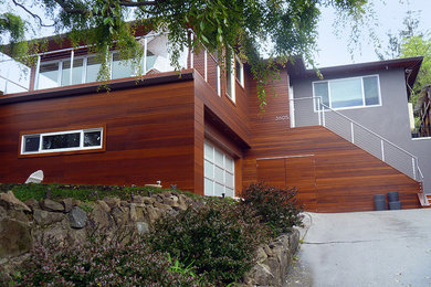 Foto de fachada de casa marrón actual grande de dos plantas con revestimiento de madera