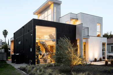 Modelo de fachada de casa negra moderna grande de dos plantas con revestimiento de madera y tejado plano