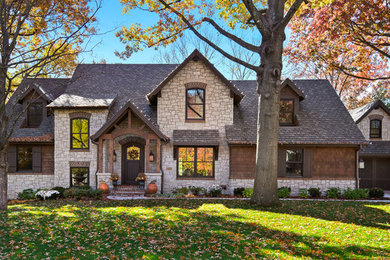Imagen de fachada de casa marrón de estilo americano de dos plantas con revestimientos combinados y tejado a cuatro aguas