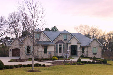 Ejemplo de fachada de casa beige de tamaño medio de una planta con revestimiento de piedra, tejado a cuatro aguas y tejado de teja de barro