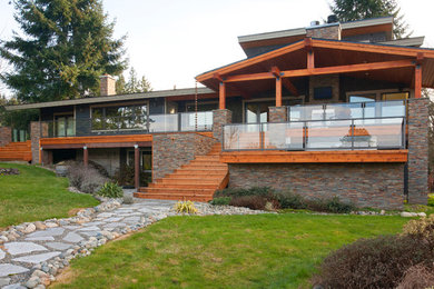 Large and gey contemporary split-level house exterior in Seattle with mixed cladding and a flat roof.