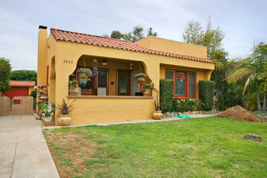 Mid-sized tuscan yellow one-story stucco flat roof photo in Other