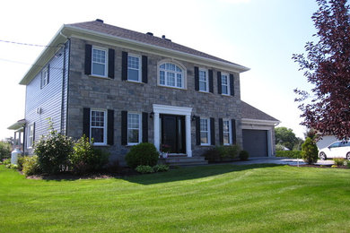 Photo of a large and gey classic two floor house exterior in Montreal with stone cladding and a hip roof.