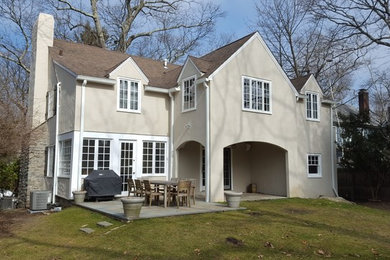 Imagen de fachada de casa beige clásica renovada grande de dos plantas con revestimiento de estuco, tejado a dos aguas y tejado de teja de madera