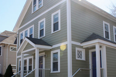 Ejemplo de fachada de casa beige moderna de tres plantas con revestimiento de madera y tejado a dos aguas
