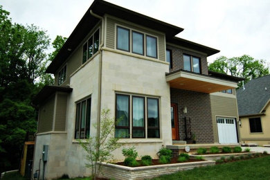 Ejemplo de fachada de casa beige tradicional renovada de tamaño medio de dos plantas con revestimientos combinados, tejado a dos aguas y tejado de teja de madera
