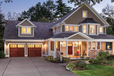 Diseño de fachada beige de estilo de casa de campo de dos plantas con revestimiento de vinilo y tejado a doble faldón