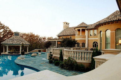На фото: двухэтажный, коричневый дом в средиземноморском стиле с облицовкой из цементной штукатурки