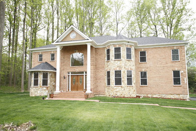 Inspiration for a large timeless brown two-story brick house exterior remodel in DC Metro with a hip roof and a shingle roof