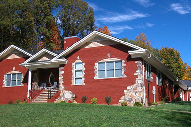 Foto de fachada de casa roja de estilo americano de tamaño medio de una planta con revestimiento de ladrillo, tejado a dos aguas y tejado de teja de madera