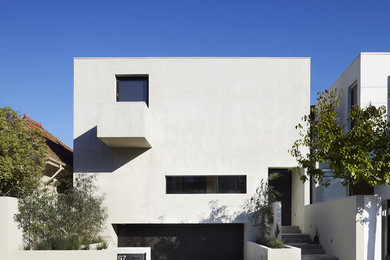 Inspiration for a medium sized and white modern house exterior in Melbourne with a flat roof.