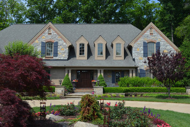 Immagine della facciata di una casa grande grigia american style a due piani con rivestimento in pietra