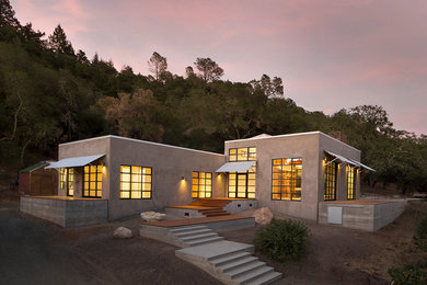 Réalisation d'une façade de maison design de plain-pied avec un toit plat.
