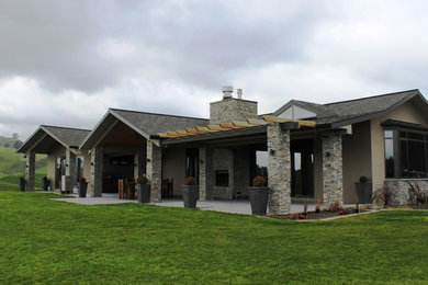 Ejemplo de fachada de casa campestre grande con revestimiento de piedra y tejado de teja de madera