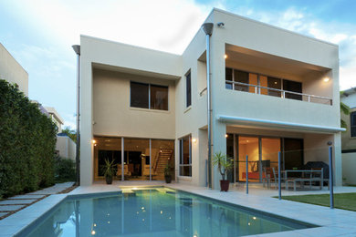 Large modern beige two-story stucco exterior home idea in Miami