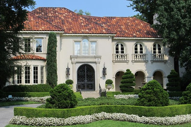 Example of a large classic beige two-story stucco house exterior design in Miami with a hip roof and a tile roof