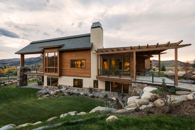 Photo of a large and brown rustic two floor house exterior in Denver with wood cladding.